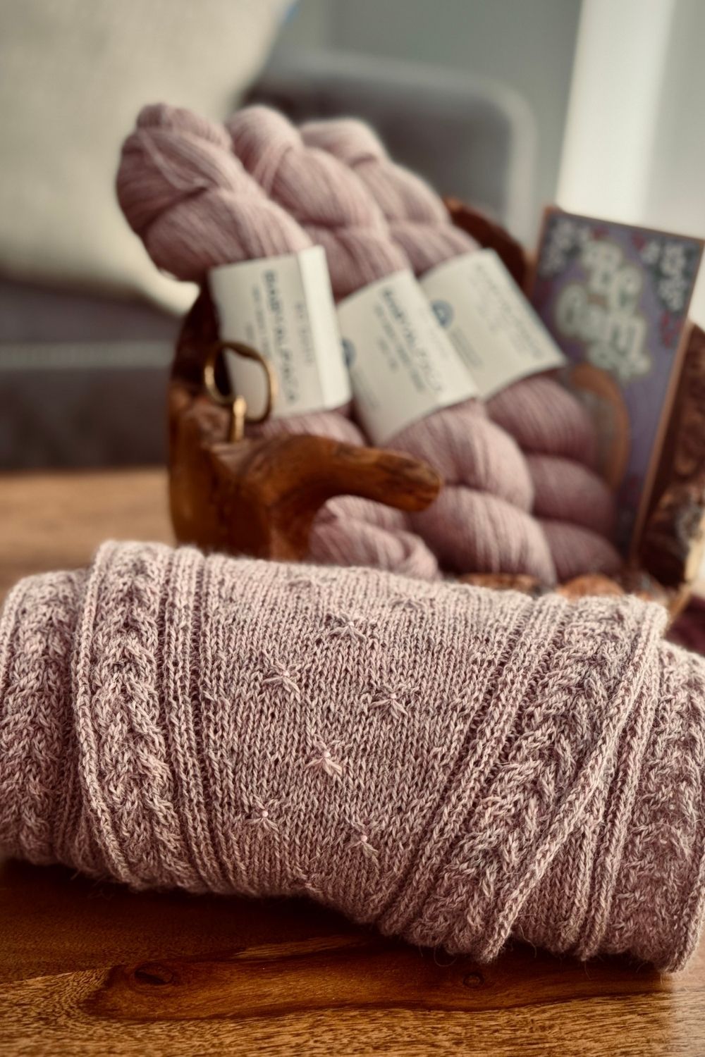 Detailansicht Strickanleitung Lyra mit Fokus auf den seitlichen Zöpfen und Wolle im Hintergrund.