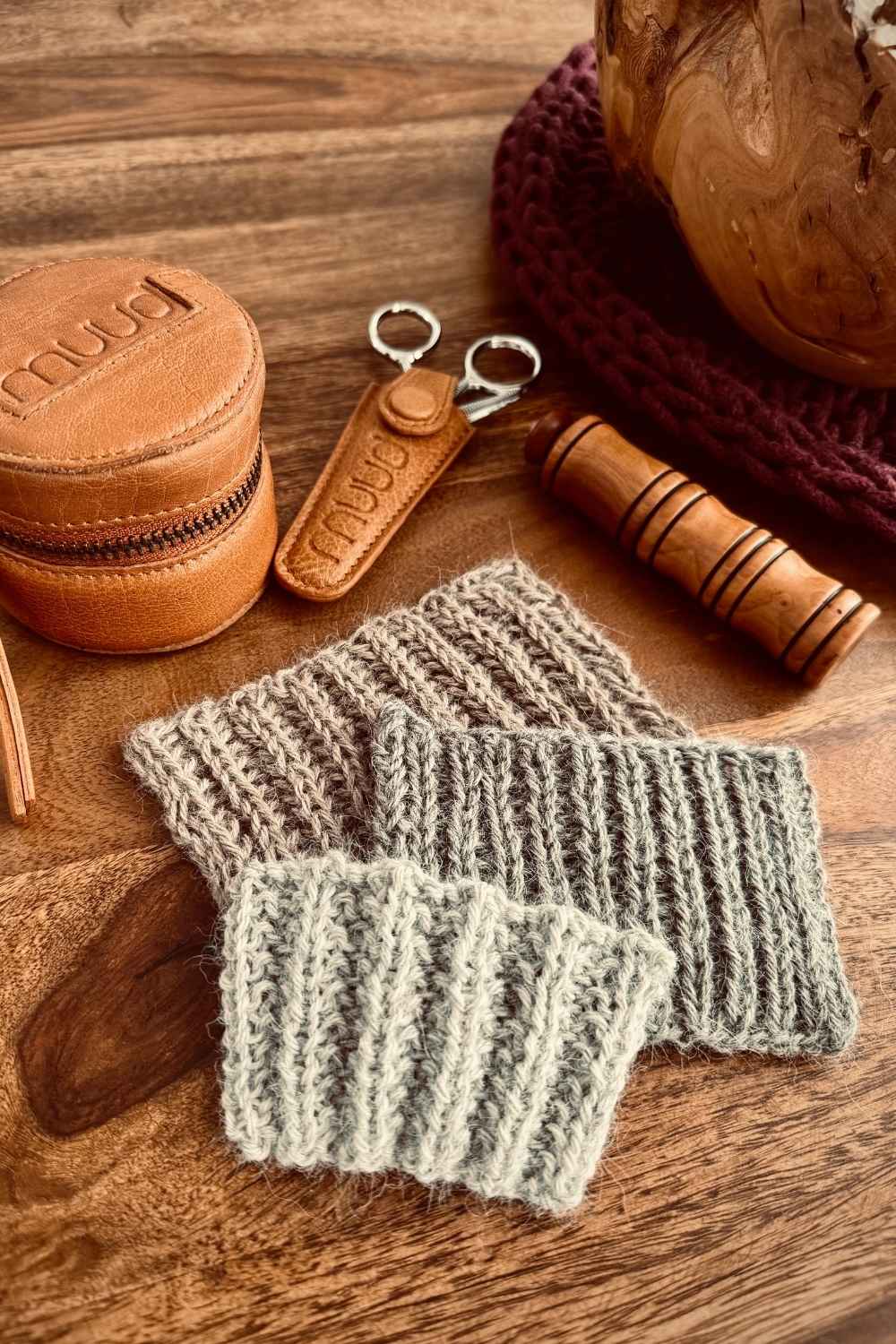 Probestücke Vollpatent, Halbpatent und falsches Patent in verschiedenen Beigetönen auf Holztisch mit Schere und Nadeldöschen