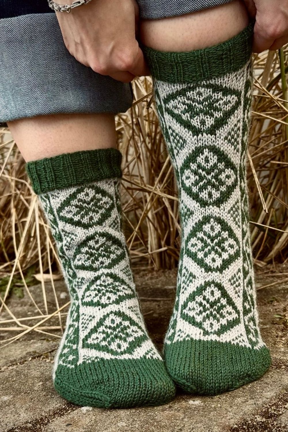 Saint Patrick Socken mit Fair Isle Muster in den Farben Grün und Natur, gezeigt am Modell