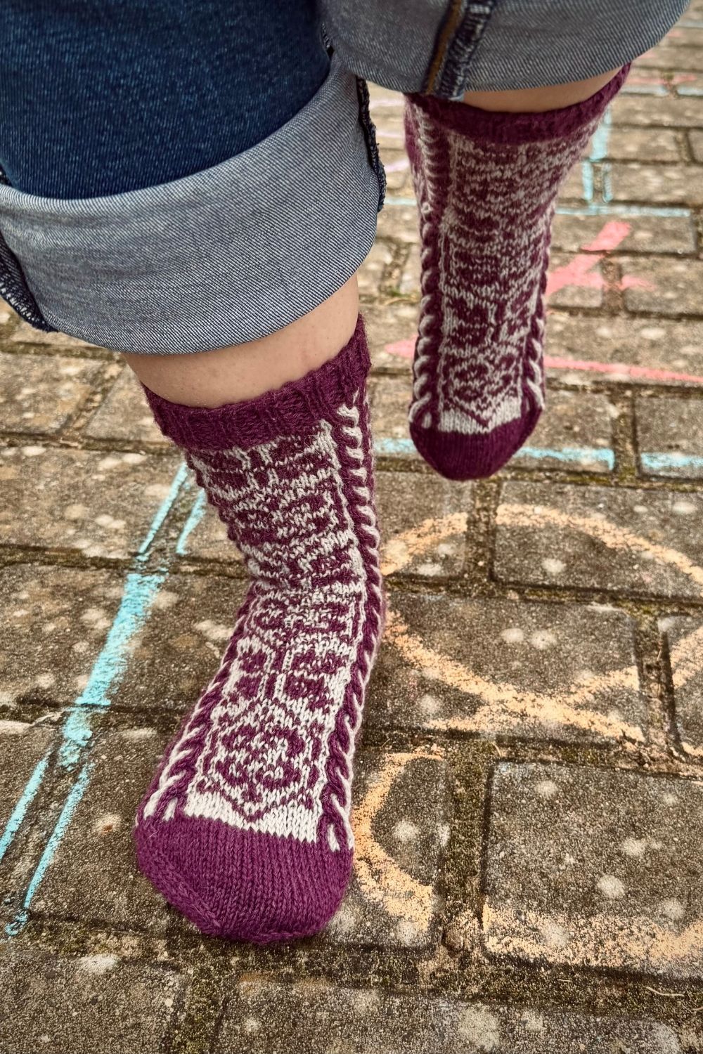 Ein Moment voller Leichtigkeit: die filigranen Socken auf einem Zahlenfeld eines klassischen Himmel und Hölle Hüpfspiels
