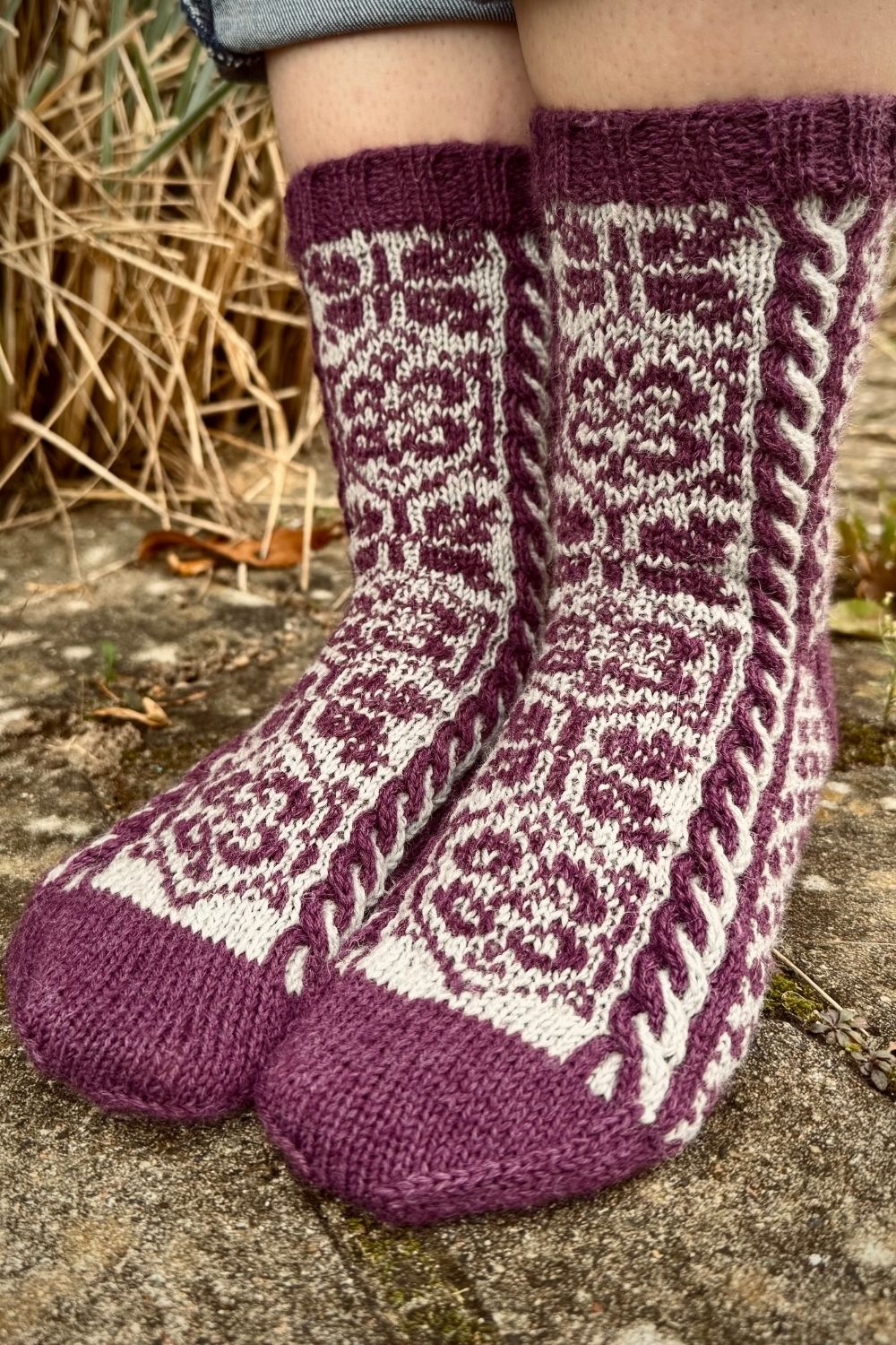 Ansicht von leicht schräg vorne auf die handgestickten Socken Lost Gardens of Heligan mit Fokus auf das Fair Isle Muster in der Mitte