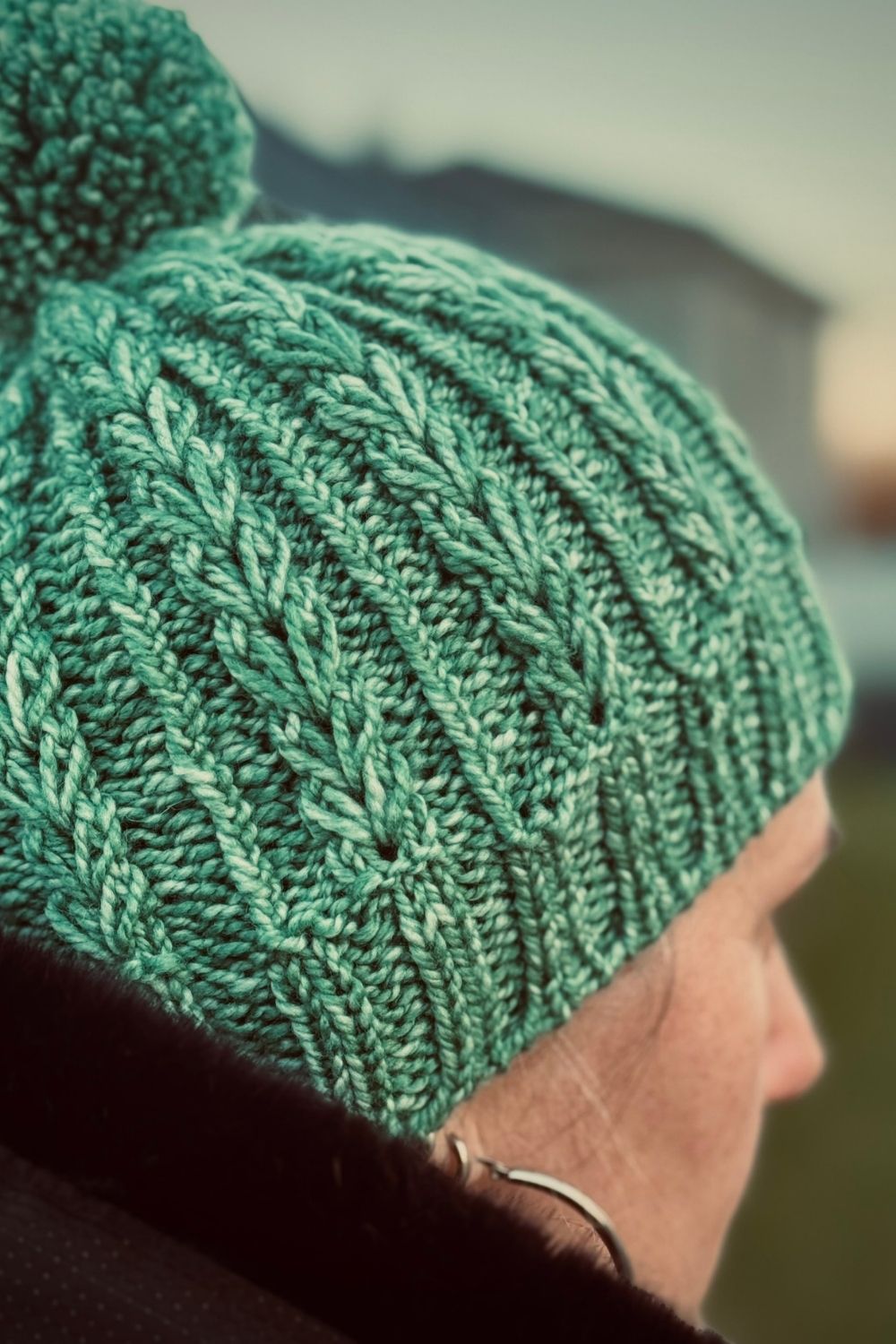 Strickmütze Elska von mir getragen, mit auffälligem Herzchenmuster und Bommel in der Farbe Grün