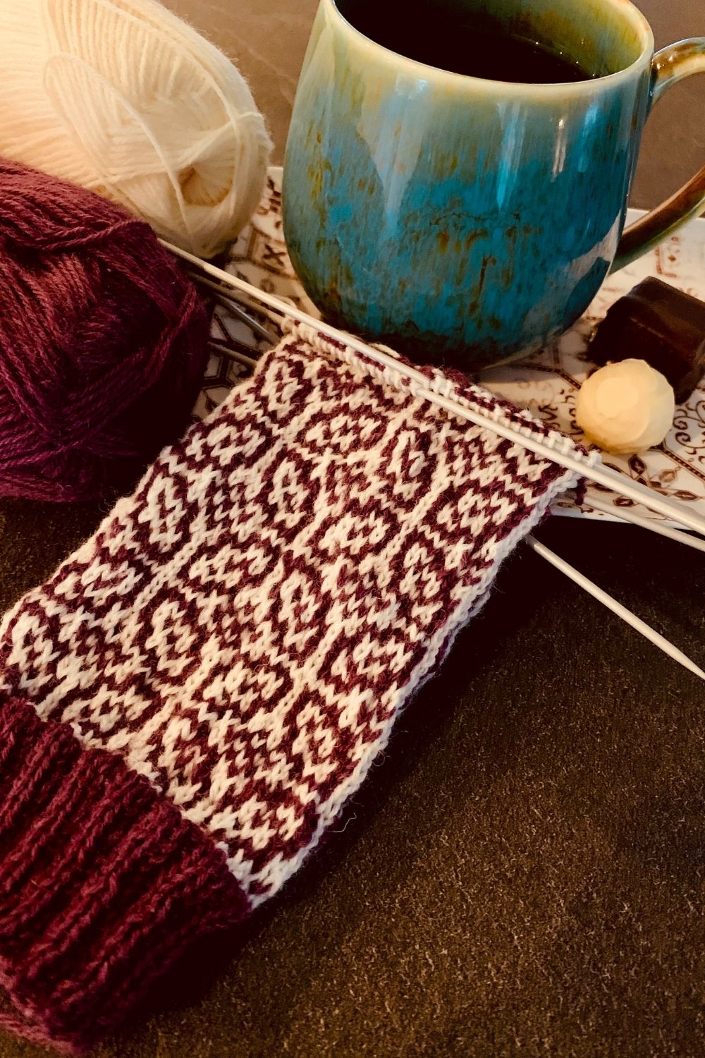 Work in progress, gestrickter Schaft der Hanami Socken mit einer Tasse Tee und Pralinen