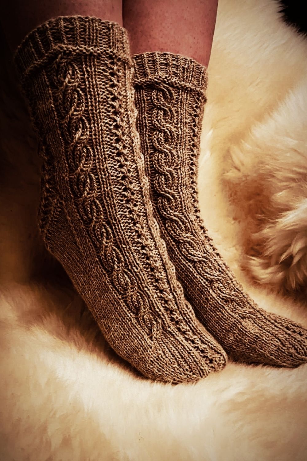 Handgestrickte Socken Wanderdüne am Modell mit Fokus auf das reliefartige Zopfmuster, Farbe Beige