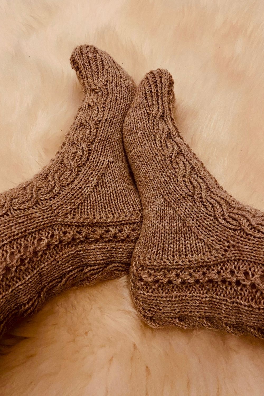 Handgestrickte Socken Wanderdüne mit Fokus auf die Rückseite und dem Lochmuster, Farbe Beige